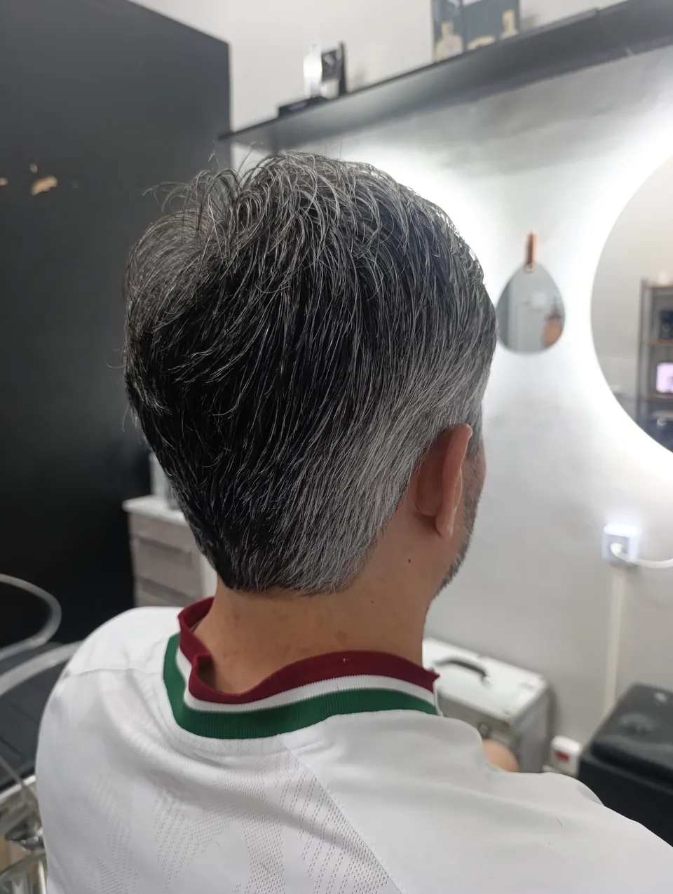 Corte masculino curto com grisalho natural, visto de trás com a nuca acabada